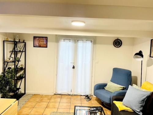 un salon avec une chaise bleue et une fenêtre dans l'établissement Yana House 1, à Corbeil-Essonnes