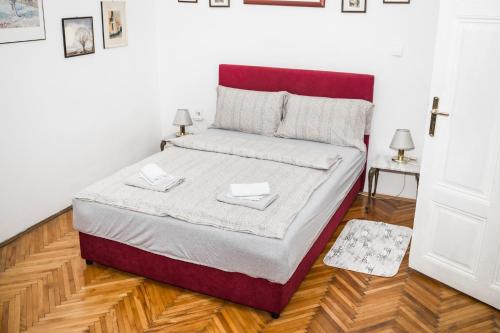 um quarto com uma cama grande e uma cabeceira vermelha em Apartment Morgan - Historic Old Town Sarajevo em Sarajevo