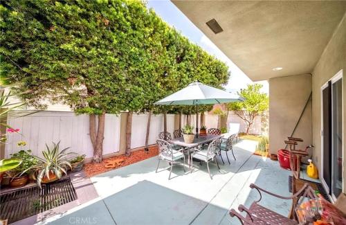 a patio with a table and chairs and an umbrella at Redondo Beach Suite, 2 BR 1st floor Surf Gym workspace in Redondo Beach