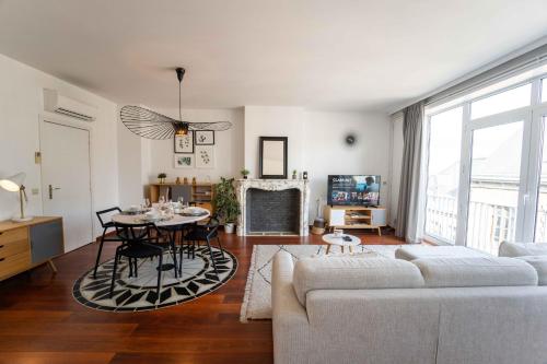 a living room with a white couch and a table at Luxury Apart' MONS City Center with Terrace in Mons