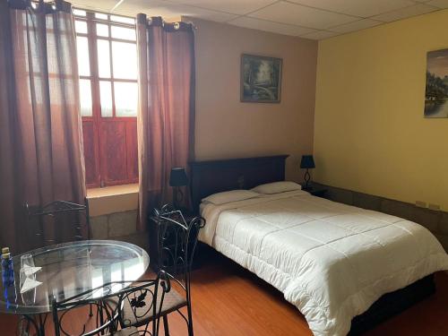 METROPOLITANO HOTEL في ريوبامبا: غرفة نوم بسرير وطاولة زجاجية