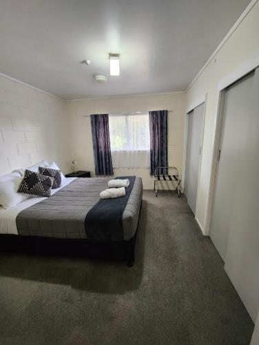 a bedroom with a large bed with two towels on it at Bay of Islands Holiday Park in Paihia