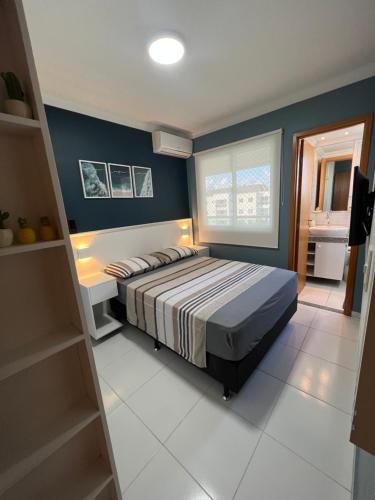 a bedroom with a bed and a blue wall at Flat Palm village in Porto De Galinhas