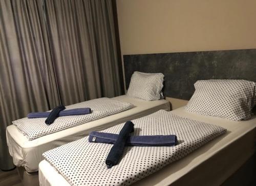 Dos camas con cruces en una habitación de hotel en Pasa Han Hotel M1autópálya, 