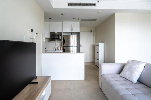 a living room with a couch and a kitchen at Burwood 1bedroom Apartment next to Station in Sydney