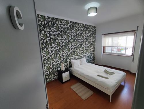 a small bedroom with a bed and a wall at Sintra, T3 with terrace in Massama, Queluz, Sintra in Queluz