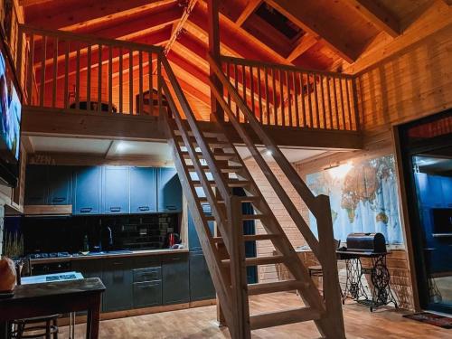 a wooden staircase in a kitchen with blue cabinets at Cucu Zen Cazare Cabane Pensiuni Bucovina in Iacobeni