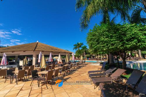 a group of chairs and umbrellas next to a pool at Apartamentos 2 Quartos- Lacqua diRoma Caldas Novas in Caldas Novas