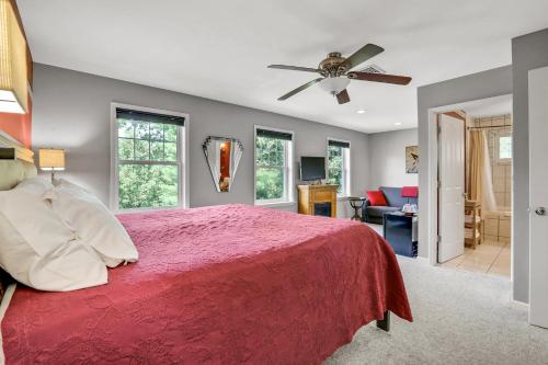 a bedroom with a red bed with a ceiling fan at Moondance Ridge Suites in New Paltz