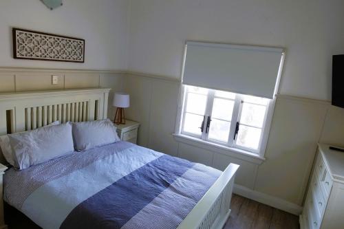 1 dormitorio con cama y ventana en Christina Cottage, en South West Rocks