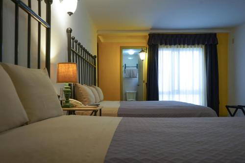 Habitación de hotel con 2 camas y ventana en Hotel Real de Leyendas, en Guanajuato