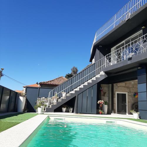 a house with a swimming pool in front of a house at Casa do Loureiro - Apartamento in Paradela