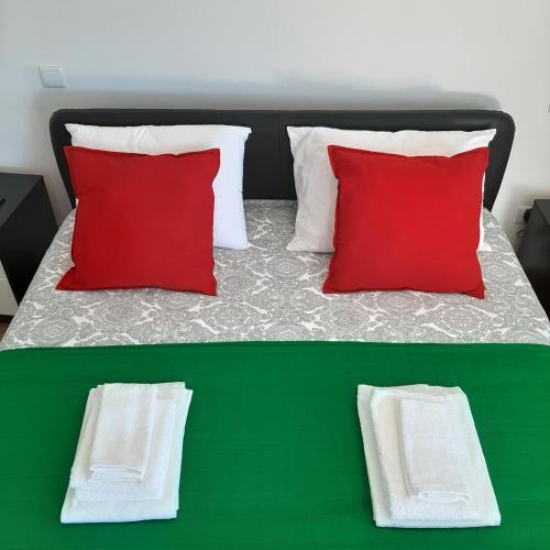 two pictures of a bed with red and white pillows at Casa do Loureiro - Apartamento in Paradela
