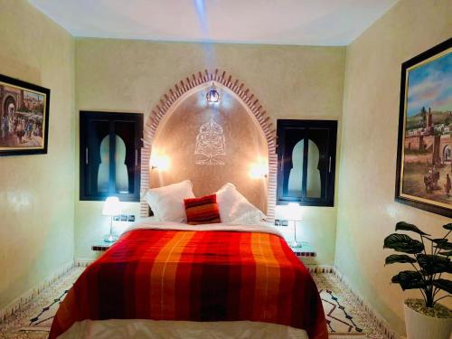 een slaapkamer met een bed met een kleurrijke deken bij Riad Ennaciri in Safi