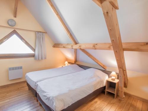 1 dormitorio en el ático con cama y ventana en Lac Bleu 25 en Lacapelle-Marival