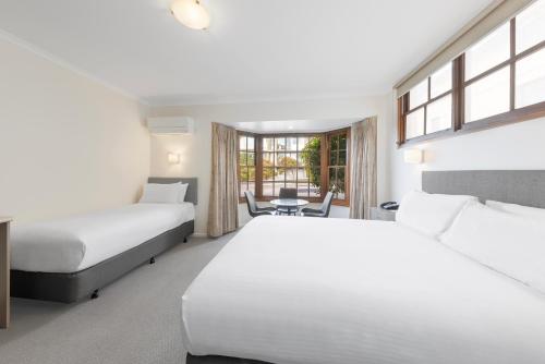 a hotel room with two beds and a window at Best Western Olde Maritime Motor Inn in Warrnambool