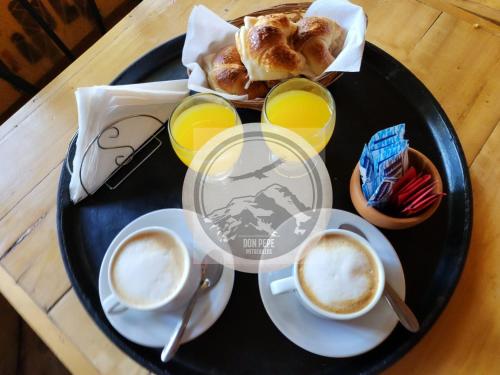 a black plate with coffee and pastries on a table at La margarita in Potrerillos