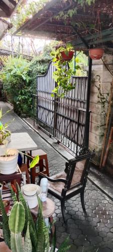 a patio with a bench and tables and plants at Lovely house near Sanur beach in Denpasar