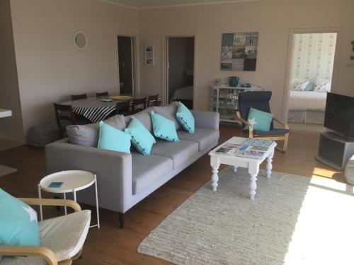ein Wohnzimmer mit einem Sofa und einem Tisch in der Unterkunft Iluka Beach House,Robe- stunning ocean views. in Robe