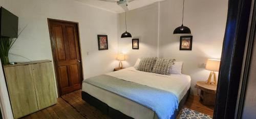 a small bedroom with a bed and two lamps at Boutique Hotel y Spa Tangara Azul in Ojochal