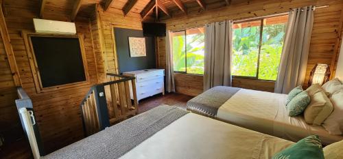 a bedroom with two beds and a flat screen tv at Boutique Hotel y Spa Tangara Azul in Ojochal