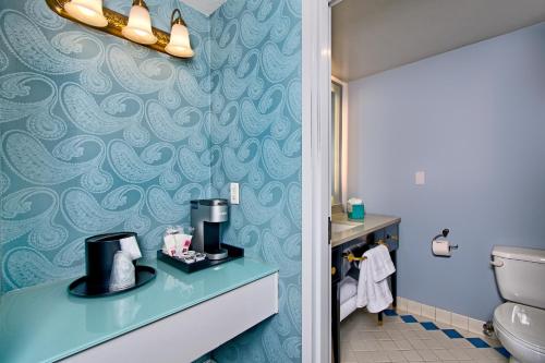 a bathroom with a toilet and a blue wall at Hotel Fiona in San Francisco