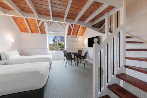 a room with a bed and a table and chairs at Best Western Olde Maritime Motor Inn in Warrnambool