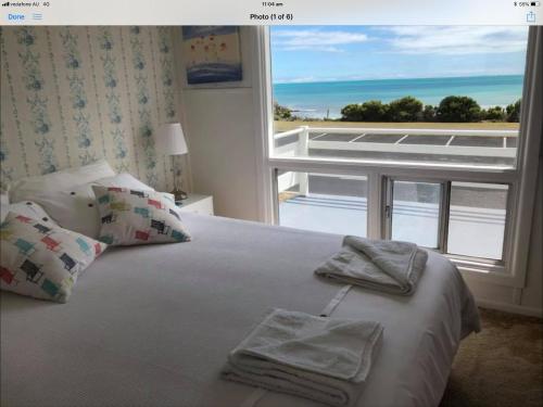 a bedroom with a bed with a view of the ocean at Iluka Beach House,Robe- stunning ocean views. in Robe