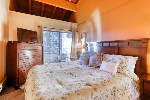 ein Schlafzimmer mit einem Bett, einer Kommode und einem TV in der Unterkunft Lakeland Village by DC in South Lake Tahoe