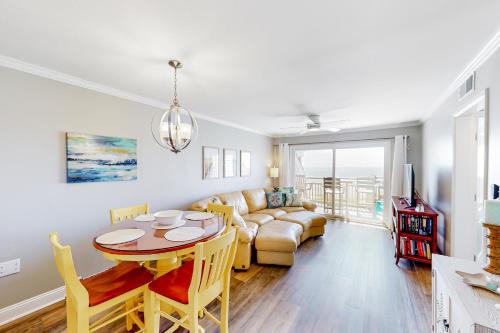 a living room with a table and a couch at CAB03 Pelicans Penthouse in Oak Island