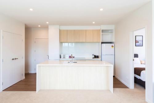 a white kitchen with a white island in a room at The Edgerley Suites in Auckland