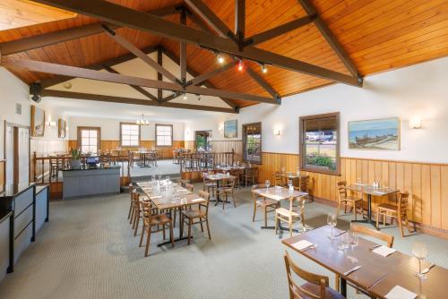 un restaurante con paredes de madera, mesas y sillas en Best Western Olde Maritime Motor Inn, en Warrnambool