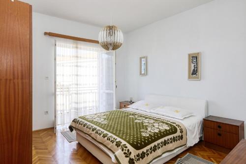 um quarto com uma cama e uma grande janela em Apartments by the sea Pirovac, Sibenik - 11824 em Pirovac