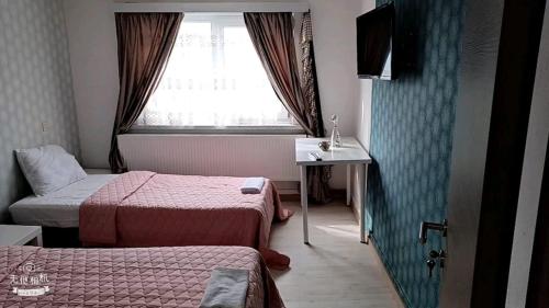 una camera d'albergo con due letti e una finestra di FMS Logie ad Anversa