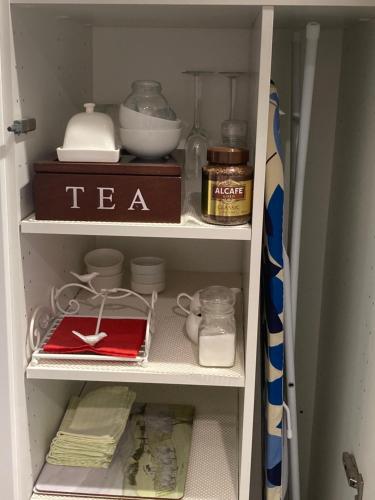 a cupboard with a tea pot and other items in it at Midgee Cottage in Mudgee