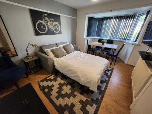 伯明罕的住宿－Greenvale Apartment，一间卧室配有一张床、一张沙发和一张桌子