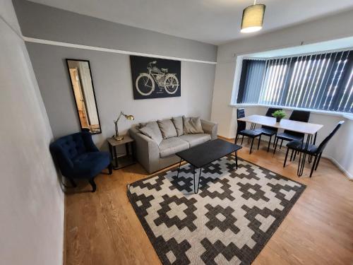 uma sala de estar com um sofá e uma mesa em Greenvale Apartment em Birmingham