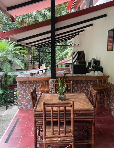 a patio with a table and chairs and a bar at The Scarlet Villas in Ojochal