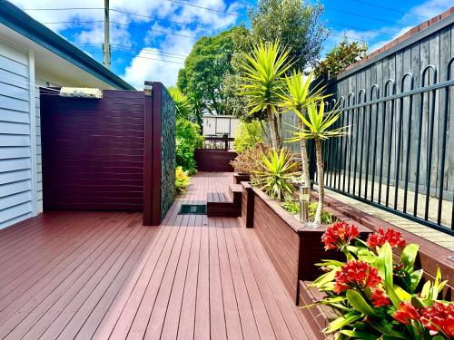 a wooden deck with plants and a fence at Albany Modern Private 2 bedroom 2 bathroom with Full Kitchen Netflix in Auckland