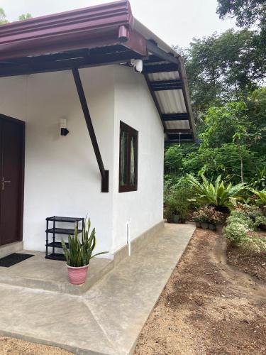 a white house with a bench in front of it at The Flora in Ahangama