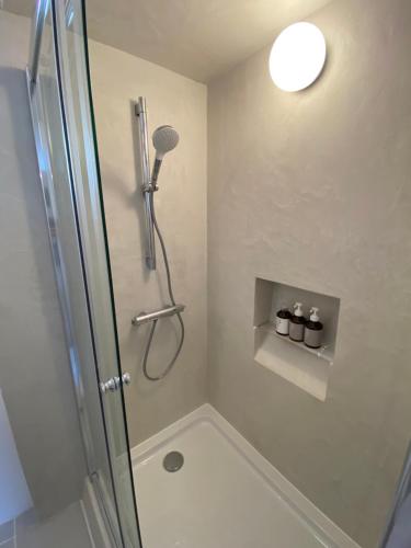 um chuveiro com uma porta de vidro na casa de banho em HUB INN 離れ em Habu