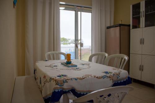 uma mesa de jantar com mesa e cadeiras em Casa do Farol em Itapoa