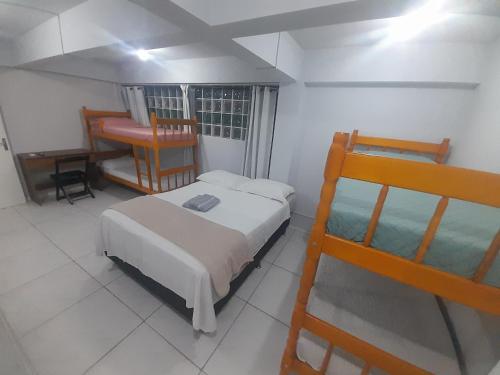 a bedroom with two bunk beds and a desk at Pousada cafe com margarida 150 metros do mar rua do calçadao da central in Balneário Camboriú