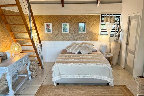 a bedroom with a bed and a staircase at BUNGALOW F2 Atypical local style in Faaa