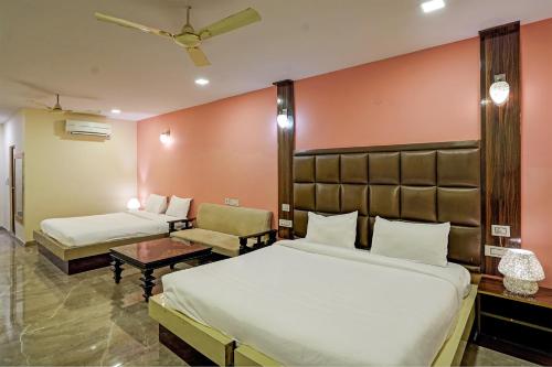 una habitación de hotel con 2 camas y una silla en Collection O RIVERIA RESORT, en Noida