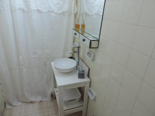 Baño blanco con lavabo y espejo en Depto 9 de Julio en Concepción del Uruguay