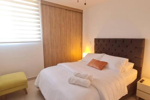 - une chambre avec un lit blanc et 2 serviettes dans l'établissement Suite La Perla, à Santa Marta