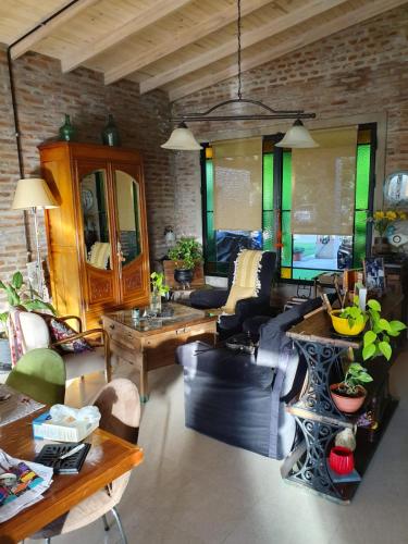sala de estar con sofá y mesa en Dormitorio con baño privado, cocina y living compartido con pileta en country en Pergamino