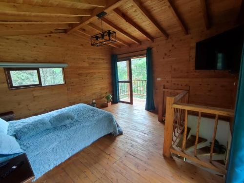 a bedroom with a bed in a log cabin at cabaña paniym in Rionegro