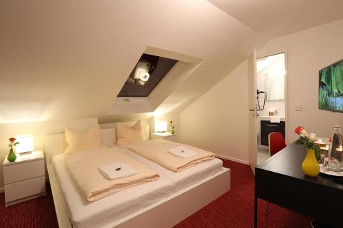 Schlafzimmer mit einem großen weißen Bett und einem Schreibtisch in der Unterkunft Mille Stelle Hotel in Eggenstein-Leopoldshafen
